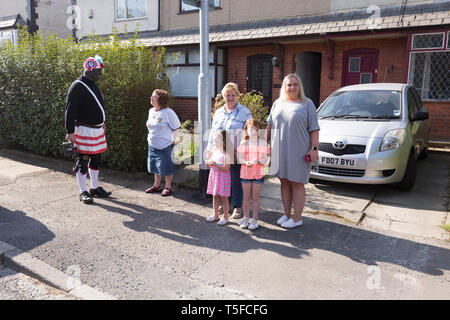 © Chris Bull. 20/04/19 Bacup, Lancashire, England. Die Morrismen der Britannia Coconutters Tanz Grenze Grenze in Bacup, Lancashire heute (Samstag, 20. April 2019). In einer Tradition zurückgehende Hunderte Jahre, jeden Ostersamstag Der morrismen haben heidnische Tänze Frühling zu begrüßen und böse Winter Spirituosen. Die Coconutters Namen aus der Zeit, als Bergleute würde Kokosnussschalen auf die Knie tragen zum Schutz in den Gruben stammt. Unterlegen Sie ihre Gesichter sie von bösen Geistern zu tarnen und auch der Bergbau Traditionen der Gegend zu reflektieren. Stockfoto