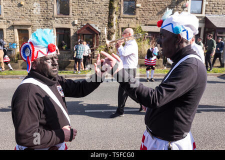 © Chris Bull. 20/04/19 Bacup, Lancashire, England. Die Morrismen der Britannia Coconutters Tanz Grenze Grenze in Bacup, Lancashire heute (Samstag, 20. April 2019). In einer Tradition zurückgehende Hunderte Jahre, jeden Ostersamstag Der morrismen haben heidnische Tänze Frühling zu begrüßen und böse Winter Spirituosen. Die Coconutters Namen aus der Zeit, als Bergleute würde Kokosnussschalen auf die Knie tragen zum Schutz in den Gruben stammt. Unterlegen Sie ihre Gesichter sie von bösen Geistern zu tarnen und auch der Bergbau Traditionen der Gegend zu reflektieren. Stockfoto