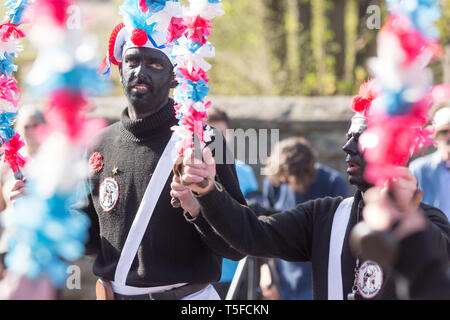 © Chris Bull. 20/04/19 Bacup, Lancashire, England. Die Morrismen der Britannia Coconutters Tanz Grenze Grenze in Bacup, Lancashire heute (Samstag, 20. April 2019). In einer Tradition zurückgehende Hunderte Jahre, jeden Ostersamstag Der morrismen haben heidnische Tänze Frühling zu begrüßen und böse Winter Spirituosen. Die Coconutters Namen aus der Zeit, als Bergleute würde Kokosnussschalen auf die Knie tragen zum Schutz in den Gruben stammt. Unterlegen Sie ihre Gesichter sie von bösen Geistern zu tarnen und auch der Bergbau Traditionen der Gegend zu reflektieren. Stockfoto