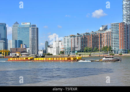 Themse Tug Boat & Schiff Container voller London Abfall Müll nach unten gezogenen Fluß für Recycling modernes Apartmentgebäude Pappel East London Großbritannien Stockfoto