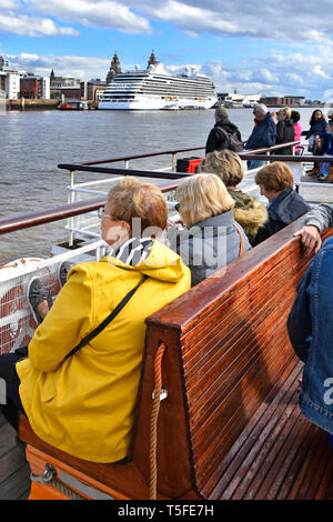 Gruppe von Leuten auf den Mersey Ferries Fähre nähert sich Liverpool Pier Head auf River Crossing von Wirral Cruise Ship Terminal über Merseyside England Großbritannien Stockfoto