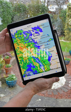 Echtzeit Farbe radardaten überlagernden Niederschlag auf der lokalen Karte regnerische Wetter auf home Fenster Händen hält Apple Ipad pro Tablette regen Alarm app Essex UK Stockfoto