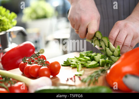 Professioneller Koch Hand Zerkleinern frische Gurke Stockfoto