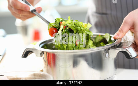 Männliche Hände mischen Organische gehackt Salat Stockfoto