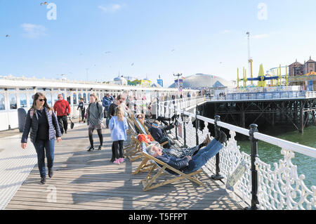 Die Menschen genießen das sonnige Wetter auf dem Boardwalk Palace Pier von Brighton, East Sussex, England, Großbritannien Stockfoto