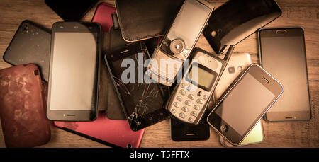 Alten, kaputten und veralteten Handys auf Holz Hintergrund, Frankreich Stockfoto