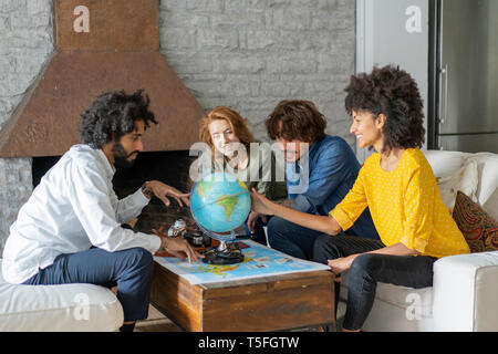 Freunde treffen Urlaub zu planen, zu prüfen Karte und Kugel Stockfoto
