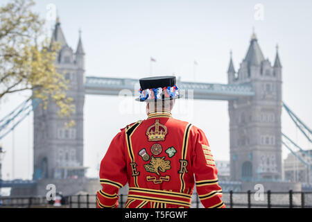 Ein Yeoman Warder (oder Beefeater) steht durch die Tower Bridge in London, UK eingerahmt. Stockfoto