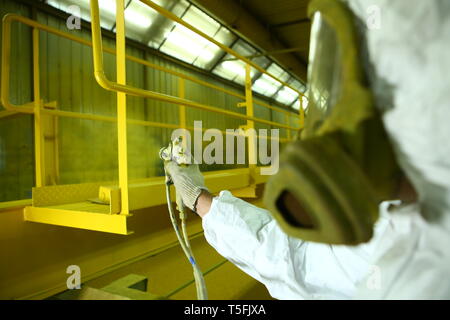 Industrielle Malerei Teile. Der Maler malt die Eisen Element in Gelb. Stockfoto