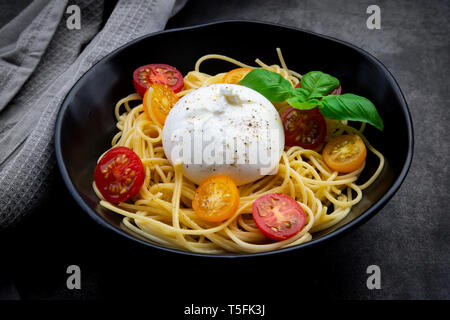 Spaghetti mit Tomaten, Burrata und Basilikum Stockfoto