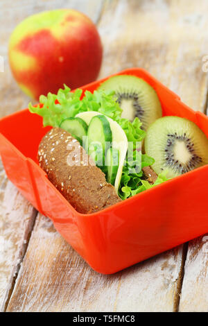 Gesunde Schule Lunch Box mit braunen Käse Sandwich, Kiwi und red apple Stockfoto