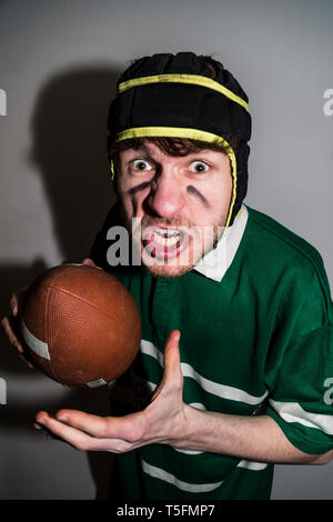 Rugby Spieler mit Ball in Hand und Gesichter machen Stockfoto