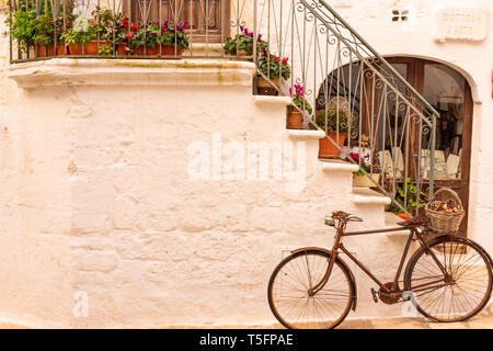 Italien, Ostuni, altes Fahrrad gegen die Wand lehnt, für Touristen. Stockfoto