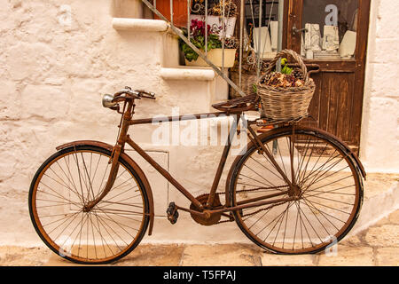 Italien, Ostuni, altes Fahrrad gegen die Wand lehnt, für Touristen. Stockfoto