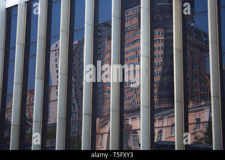 Stadtbild Reflexion über Gebäude gestreifte Glaswand mit Verzerrung in der Innenstadt an einem Frühlingstag Stockfoto