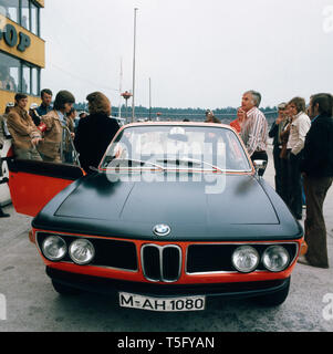 Joachim Fuchsberger und sein Sohn beäugen einen BMW am Rande des Hockenheimrings, Deutschland 1970er. Joachim Fuchsberger und sein Sohn ein BMW am Rande der Hockenheimring, Deutschland 1970 Watch s Stockfoto