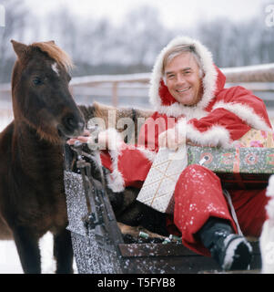 Joachim Fuchsberger in einem Weihnachtsmannkostüm Ca. 1970. Joachim Fuchsberger in einem Santa Claus kostüm Ca. 1970 Stockfoto