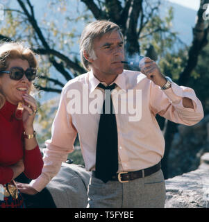 Joachim Fuchsberger e rauchend neben einer Freundin der Familie, Spanien Ca. 1970er. Joachim Fuchsberger ist Rauchen neben einem Freund der Familie, Griechenland ca 1970er Stockfoto