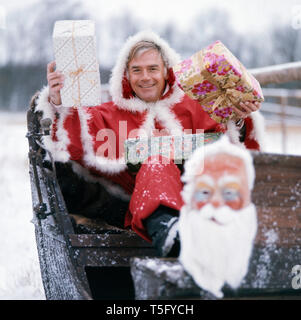 Joachim Fuchsberger in einem Weihnachtsmannkostüm Ca. 1970. Joachim Fuchsberger in einem Santa Claus kostüm Ca. 1970 Stockfoto