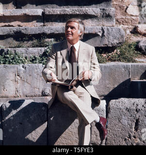 Joachim Fuchsberger liest ein Script in dem Theater von Delphi Ca. 1970er. Joachim Fuchsberger liest ein Script in einem antiken Theater circa 1970 s Stockfoto