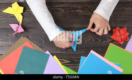 Man Hände erstellen Sie wunderschöne origami Spielzeug. Stockfoto