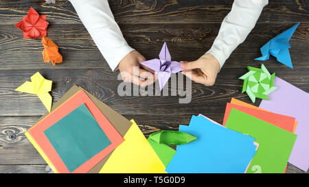 Mans Hände tun origami Blume. Stockfoto