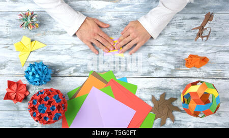 Männliche Hände falten origami Spielzeug. Stockfoto