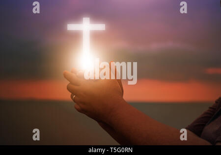 Christliche Frau Anbetung bei Sonnenuntergang zu beten. Hände gefaltet im Gebet Gott anbeten mit christlichen Begriff der Religion. Eucharistie Therapie segne Gott helfen Re Stockfoto