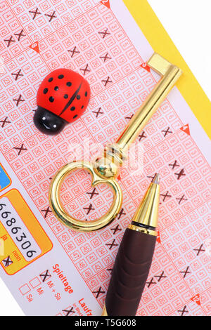 Lotterie - einen ausgefüllten Lottoschein mit Stift und Glück Symbole. Stockfoto