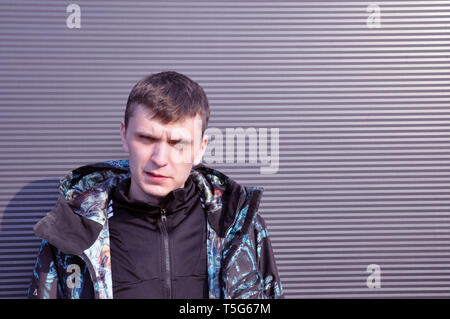 Hübscher junger Mann. Porträt eines jungen Mannes in einer Jacke, steht auf einem schwarzen Hintergrund Stockfoto
