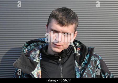 Hübscher junger Mann. Porträt eines jungen Mannes in einer Jacke, steht auf einem schwarzen Hintergrund Stockfoto