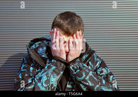 Hübscher junger Mann. Porträt eines jungen Mannes in einer Jacke, steht auf einem schwarzen Hintergrund Stockfoto