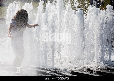 Berlin, Deutschland. 24 Apr, 2019. Ein Mädchen geht durch den Brunnen im Lustgarten. Credit: Christoph Soeder/dpa/Alamy leben Nachrichten Stockfoto