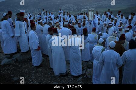 Nablus, palästinensische Gebiete. 25 Apr, 2019. Mitglieder der Samariter Gemeinschaft sammeln auf dem Berg Garizim, um an einem frühen Morgen Pessah Gebete zum Ende des Passah Urlaub zu markieren, in der Nähe der Stadt Nablus im Westjordanland. Die Samariter, ein ethnoreligious Gruppe des Levant aus der Israeliten oder Hebräer, des Alten Orients, Claim Abstieg vom Stamm Ephraim und Stamm Manasse (zwei Söhne von Joseph). Nach der Thora, das Passah schlachten erste war in der Nacht von den Israeliten Exodus aus Ägypten angeboten. Credit: Ayman Nobani/dpa/Alamy leben Nachrichten Stockfoto