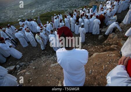 Nablus, palästinensische Gebiete. 25 Apr, 2019. Mitglieder der Samariter Gemeinschaft sammeln auf dem Berg Garizim, um an einem frühen Morgen Pessah Gebete zum Ende des Passah Urlaub zu markieren, in der Nähe der Stadt Nablus im Westjordanland. Die Samariter, ein ethnoreligious Gruppe des Levant aus der Israeliten oder Hebräer, des Alten Orients, Claim Abstieg vom Stamm Ephraim und Stamm Manasse (zwei Söhne von Joseph). Nach der Thora, das Passah schlachten erste war in der Nacht von den Israeliten Exodus aus Ägypten angeboten. Credit: Ayman Nobani/dpa/Alamy leben Nachrichten Stockfoto