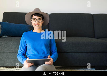Porträt der lächelnde Frau im Wohnzimmer mit einem Tablet Zimmer Stockfoto