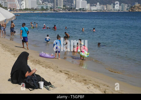 Frau in heißen religiöse Kleidung am Strand von Acapulco, Mexiko Stockfoto