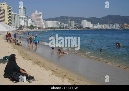 Frau in heißen religiöse Kleidung am Strand von Acapulco, Mexiko Stockfoto