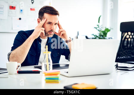 Konzentrierte Geschäftsmann Arbeiten am Laptop auf dem Schreibtisch im Büro Stockfoto