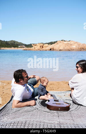 Spanien, Menorca, Familie zusammen am Strand entspannen Stockfoto