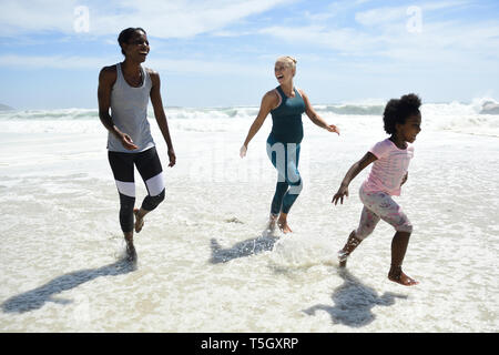Mutter mit Tochter und Freund Spaß in Surfen am Strand Stockfoto