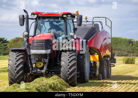 Kirwee, Canterbury, Neuseeland, 27. März 2019: ein Fall Presse und Traktor am Arbeitsplatz die Heuballen auf der Südinsel landwirtschaftliches Feld Tage Veranstaltung Stockfoto