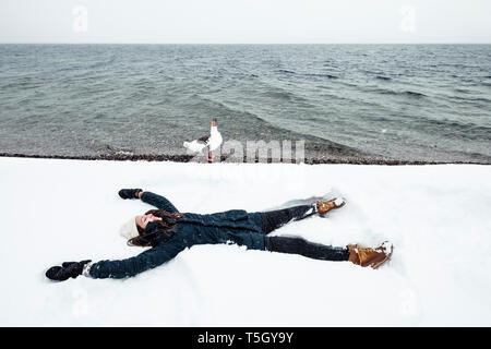 Grey Goose und junge Frau im Starnberger See im Winter Stockfoto