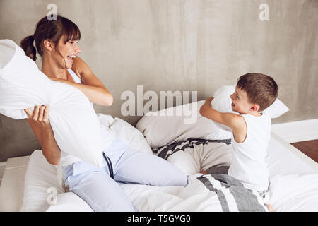 Mutter und Sohn Spaß haben, in einer Kissenschlacht im Bett Stockfoto