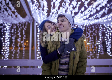 Glückliches junges Paar umarmen im Winter Dekoration Stockfoto