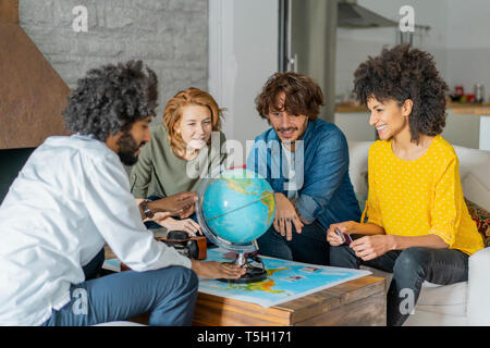 Freunde treffen Urlaub zu planen, zu prüfen Karte und Kugel Stockfoto