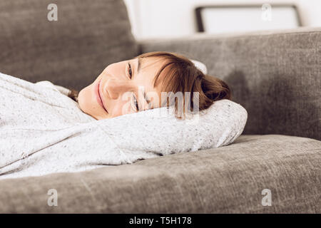 Reife Frau entspannen auf der Couch, Tagträumen Stockfoto