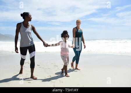 Glücklich, Mutter mit Tochter und Freund zu Fuß am Strand Stockfoto