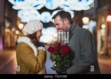 Mann gifting seine Freundin Strauß roter Rosen am Valentinstag Stockfoto