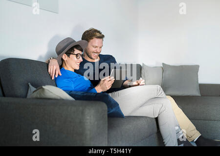 Gerne lässig ein paar entspannende über Tablet couch Stockfoto